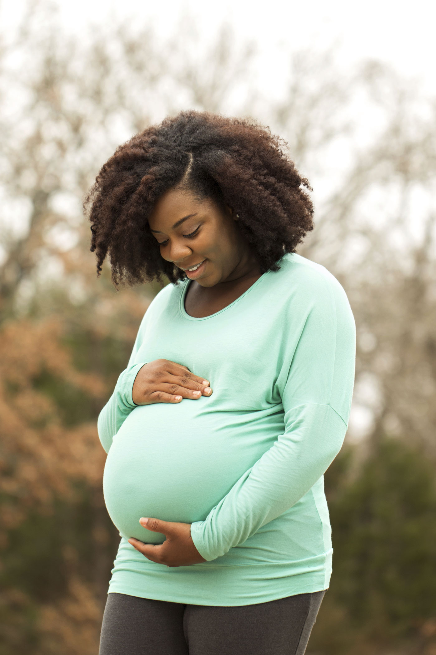 African American Pregnant woman holding stomach